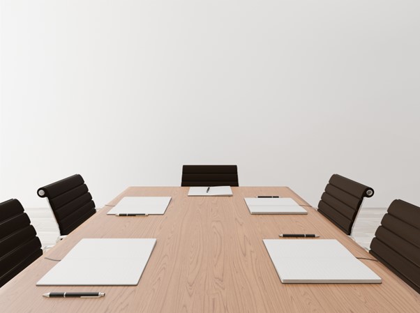 An empty minimalist boardroom with black chairs.